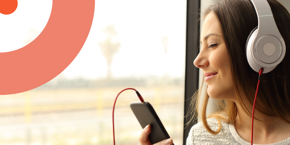 Une femme écoute son livre audio dans le train les yeux fermés.